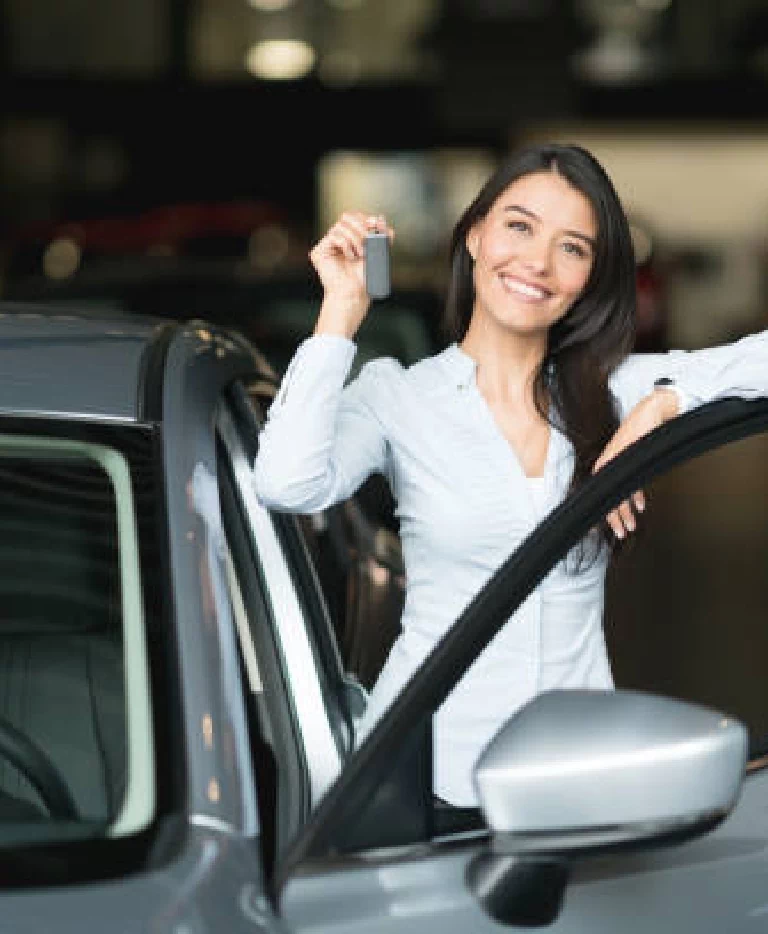 Uśmiechnięta kobieta trzymająca klucze do auta