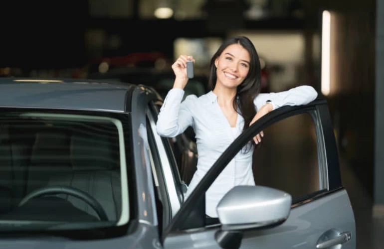 Uśmiechnięta kobieta trzymająca klucze do samochodu
